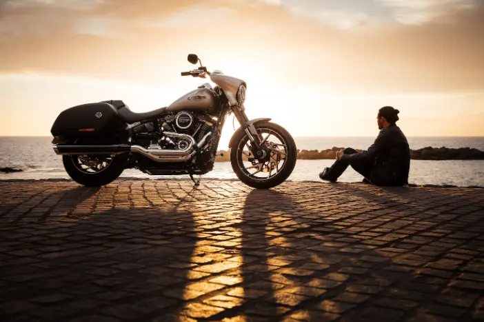 Parked silver cruiser Motorcycle with man sitting beside